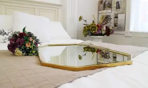 Eleganckie feng shui lustro na łóżku, odbijające bukiet kwiatów i dekoracje ścienne, tworzy harmonijną przestrzeń.