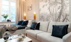 Impresjonująca dekoracja ściany nad narożnikiem z motywem leśnym. Wygodna sofa i łóżko tworzą przytulną przestrzeń.