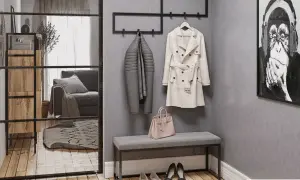 Przedpokój loft inspiracje: szary płaszcz, beżowy trencz, różowa torebka i obraz z małpą.