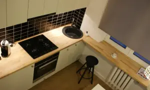 Nowoczesna kuchnia z drewnianym blatem, płytą indukcyjną i zlewem. Montaż blatu kuchennego zakończony sukcesem.