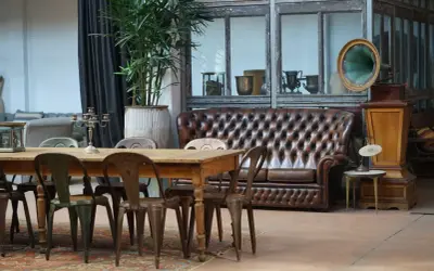 Stary gramofon i skórzana kanapa w salonie. Inspiracja, co zrobić ze starymi meblami, by nadać im nowy charakter.