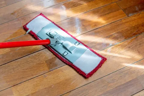 Mop na drewnianej podłodze. Poznaj domowe sposoby, jak nabłyszczyć płytki i drewno, by lśniły jak nowe.