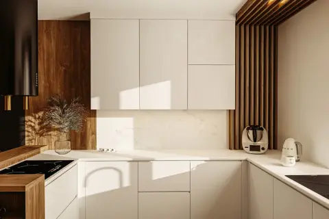Nowoczesna kuchnia z białymi frontami, drewnianymi akcentami i czarnym okapem. Widoczny system gola w szafkach, idealnie wkomponowany w design.