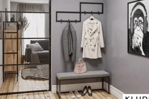 Przedpokój loft inspiracje: szary płaszcz, beżowy trencz, różowa torebka i obraz z małpą.
