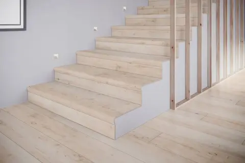 Schody z płytek drewnopodobnych w jasnym odcieniu, tworzące przytulne inspiracje. Drewniany balustrada i subtelne oświetlenie dodają elegancji.