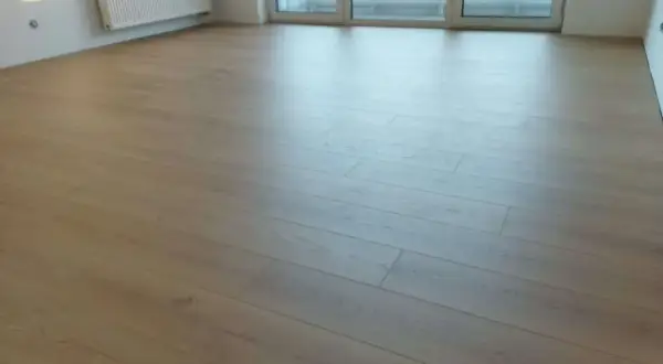 Nowe panele ułożone równolegle do okna, tworząc jasną i przestronną przestrzeń.