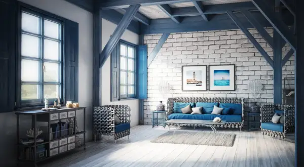 Salon w stylu coastal, z niebieskimi akcentami, ceglaną ścianą i widokiem na morze na obrazach.