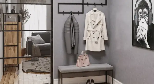 Przedpokój loft inspiracje: szary płaszcz, beżowy trencz, różowa torebka i obraz z małpą.
