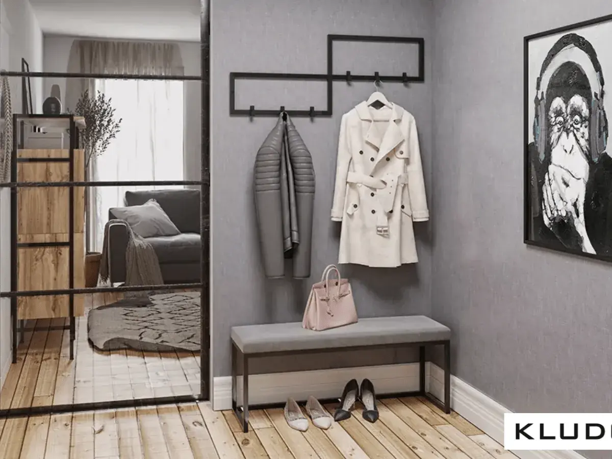 Przedpokój loft inspiracje: szary płaszcz, beżowy trencz, różowa torebka i obraz z małpą.