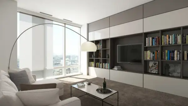 Nowoczesny salon z dużą biblioteczką i TV, idealny do przechowywania w małym mieszkaniu. Jasne wnętrze, wygodna sofa i panoramiczne okno.